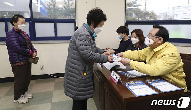 울산형 긴급재난지원금 지급 첫날인 1일 울산시 남구 신정5동 행정복지센터에서 송철호 울산시장이 시민들에게 긴급재난지원금 카드를 나눠주고 있다. 울산시는 이날부터 전 세대당 긴급재난지원금 10만원 씩을 무기명 선불카드로 지급한다. 2021.2.1/뉴스1 © News1 윤일지 기자