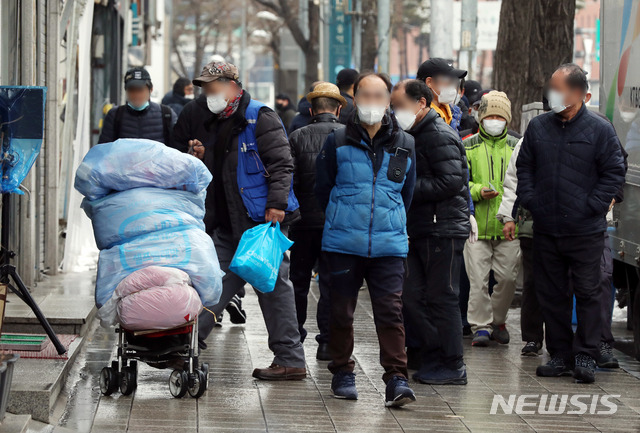 [서울=뉴시스]김병문 기자 = 노숙인들이 28일 오전 서울 용산구 서울역 인근 한 무료급식소 앞에서 배식을 기다리고 있다. 신종 코로나바이러스 감염증(코로나19) 확진자가 발생한 서울역 희망지원센터는 지난 26일부터 운영이 중단되고 있다. 2021.01.28.  dadazon@newsis.com