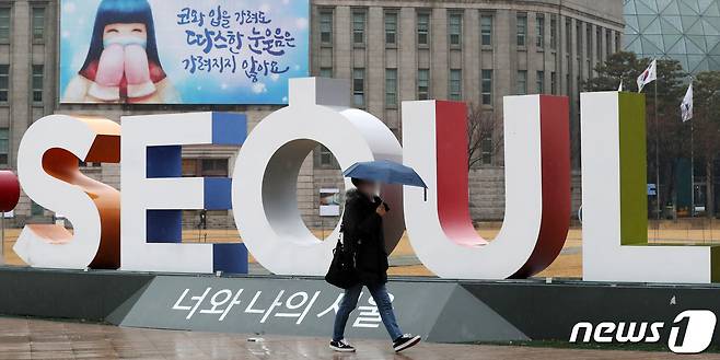 지난 달 26일 서울 중구 서울시청 앞 아이·서울·유 조형물 주변을 우산을 쓴 시민이 지나가고 있다. 2021.1.26/뉴스1 © News1 민경석 기자