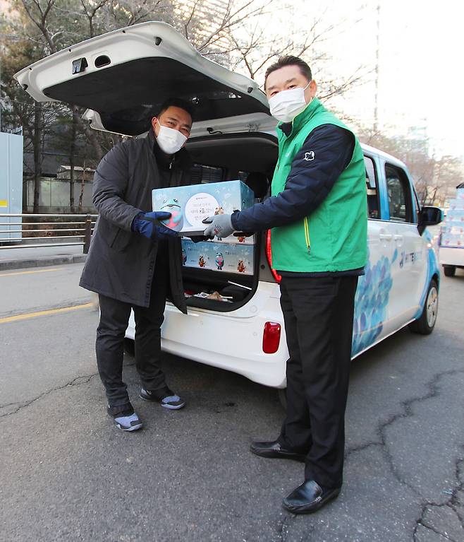 하이트진로 김인규 대표(오른쪽)는 곰달래어르신복지센터 강현구 사회복지사에게 설 맞이 떡국 재료(가래떡, 만두)를 2일 서초동 본사 사옥 앞에서 전달했다. 하이트진로는 이날 34개 사회복지기관에 약 1만인분의 음식을 지원했다.