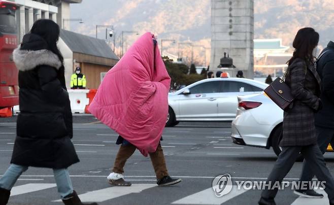 추워요 (서울=연합뉴스) 백승렬 기자 = 화요일인 2일은 북서쪽 찬 공기의 영향으로 기온이 크게 떨어져 추운 가운데 오후부터 일부 지역에서 눈이 내리겠다. 사진은 기온이 영하로 내려간 서울 광화문 네거리에서 한 시민이 이불을 두르고 횡단보도를 건너고 있다. 2021.2.2 srbaek@yna.co.kr