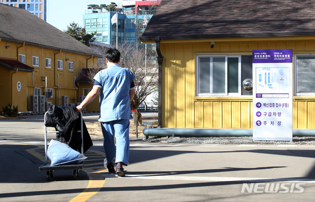 [서울=뉴시스]김병문 기자 = 수도권 의료기관 의료진을 중심으로 신종 코로나바이러스 감염증(코로나19) 첫 예방접종을 진행할 서울 중구 국립중앙의료원 코로나19 격리치료병동 내 백신 중앙접종센터 앞을 2일 오전 관계자들이 지나가고 있다. 2021.02.02. dadazon@newsis.com