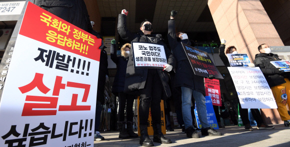 보건복지부 중앙사고수습본부가 2일 개최한 ‘거리두기 단계 개편을 위한 공개토론회’가 진행된 서울 중구 LW컨벤션 앞에서 자영업자들이 ‘생존권을 보장하라’ 등이 쓰인 푯말을 들고 영업시간 연장 등 방역지침 완화를 촉구하는 시위를 벌이고 있다.박윤슬 기자 seul@seoul.co.kr