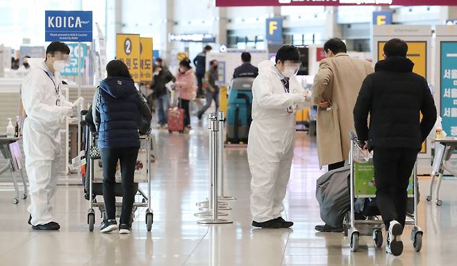 영국발 변이 바이러스의 첫 지역사회 집단감염 사례가 발생한 가운데 4일 오전 인천국제공항 제1터미널에서 방역관계자들이 해외입국자 어깨에 식별스티커를 붙이고 있다. 중앙방역대책본부에 따르면 이날 0시 기준 국내 코로나19 신규 확진자 수는 451명으로 이중 지역발생이 429명, 해외유입이 22명으로 나타났다. [연합]