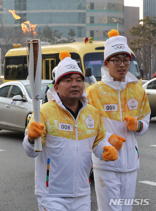 【서울=뉴시스】박진희 기자 = 2018 평창동계올림픽 성화봉송 서울 셋째 날인 15일 오전 서울 강남구 삼성역에서 바르셀로나 올림픽 마라톤 금메달리스트 황영조가 성화봉송을 하고 있다. 2018.01.15.pak7130@newsis.com