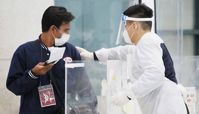 해외입국자 식별용 스티커 부착 - 4일 오전 인천국제공항 제1터미널 입국장에서 방역 관계자가 한 해외 입국자의 어깨에 식별 스티커를 부착하고 있다. 영국발 변이 바이러스의 지역사회 감염이 전날 확인된 가운데, 방역 당국은 4일“오는 3월 변이 바이러스에 의한‘4차 대유행’이 발생할 가능성을 배제할 수 없다”고 발표했다. /연합뉴스