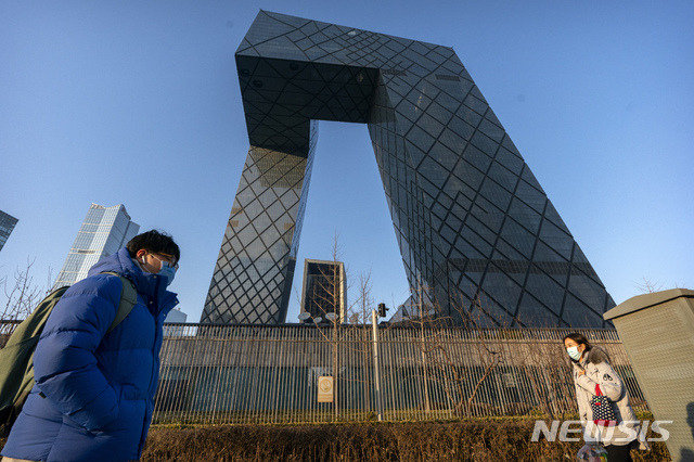 [베이징=AP/뉴시스]중국의 국제 영어 위성뉴스 채널 CGTN의 베이징 본사 건물 앞을 4일 신종 코로나바이러스 감염증(코로나19) 감염을 막기 위해 마스크를 쓴 사람들이 지나가고 있다. 영국 방송·통신 규제 기관 오프컴은 이날 CGTN의 영국 내 방송 면허를 박탈했다. 2021.2.5