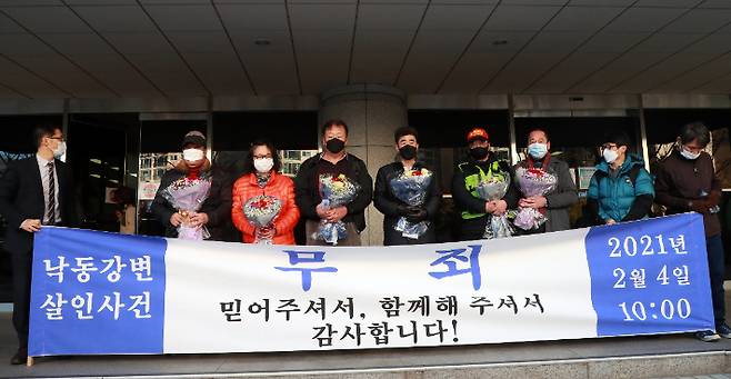 경찰 고문에 못 이겨 살인죄 누명을 쓴 채 21년간 억울한 옥살이를 한 '낙동강변 살인사건' 피해 당사자 최인철(왼쪽 네 번째)씨와 장동익씨(왼쪽 다섯 번째)가 지난 4일 오전 부산고등법원에서 열린 재심 선고 공판을 마치고 가족들과 꽃다발을 들고 있다. 연합뉴스