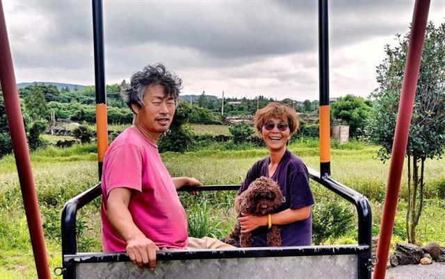 제주 ‘삼달다방’지기 이상엽(왼쪽)씨와 배우자 박옥순씨가 장애인과 비장애인이 함께 탈 수 있는 ‘휠체어 그네’에 올랐다. 배우자 박씨는 전국장애인차별철폐연대 사무총장이다.이상엽 부부 제공