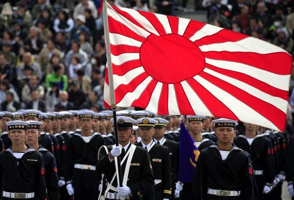 - 일본 해상 자위대가 지난해 10월 도쿄 아사카 훈련장에서 사열행사를 갖고 있다. 일본은 군국주의 상징인 ‘욱일기’를 앞세우며 군사대국화 야욕을 드러내고 있다. EPA 연합뉴스