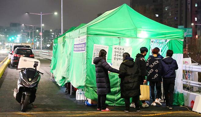 ‘움직이는 청소년 센터 엑시트’ 활동가들이 1월22일 저녁 서울 신림사거리 봉림교 옆에서 청소년 지원 활동을 준비하고 있다. 코로나19 1년, 지방자치단체가 운영하는 13곳의 이동형 아웃리치 버스가 비대면으로 전환한 뒤로 대면 방식으로는 유일하게 남은 거리 청소년 아웃리치 현장이다. 장철규 선임기자 chang21@hani.co.kr