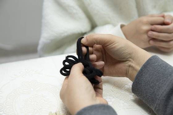 기본 뜨기로 소의 입 부분을 만드는 모습. 1번 양말목을 돌돌 만 뒤 2번 양말목을 반으로 접어 그사이에 넣는다.