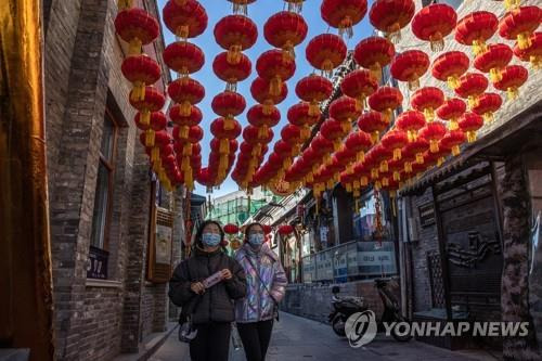 춘제 장식물 아래로 걸어가는 중국 베이징 시민들 [EPA=연합뉴스 자료사진]