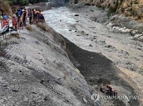 7일 인도 북부 우타라칸드주 히말라야 고산지대에서 발생한 홍수와 관련해 생존자를 수색하는 구조대와 경찰. [로이터=연합뉴스]