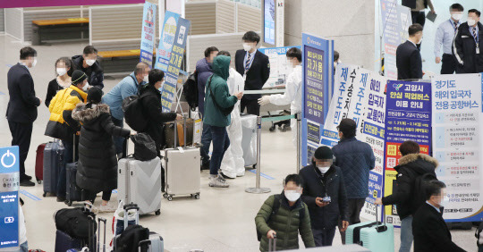 설 연휴를 이틀 앞둔 9일 오전 인천국제공항 제1터미널 입국장에서 해외입국자들이 방역관계자의 설명을 듣고 있다.  연합뉴스