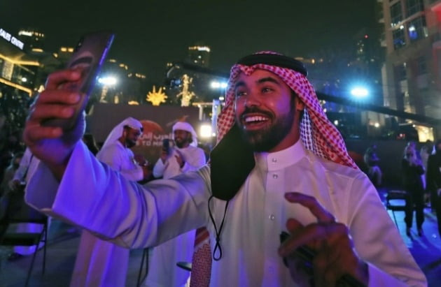 UAE 두바이에서 한 남성이 아말의 화성궤도 진입 소식을 듣고 축하하는 영상을 찍고 있다. / 사진=AP