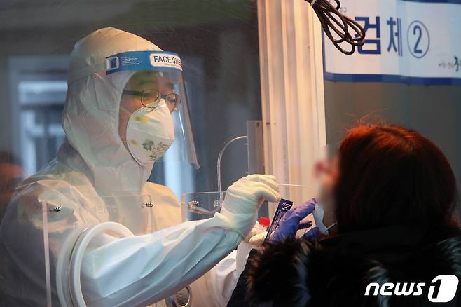 11일  서울역 광장에 마련된  코로나19  중구 임시선별검사소에서 의료진이 검사에 나선 시민의 검체를 체취하고 있다. 2021.2.11/뉴스1 © News1 박정호 기자