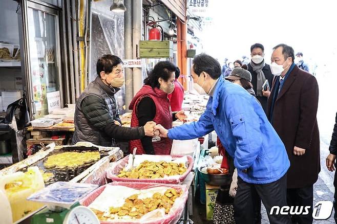 11일 서울 동대문 현대시장을 방문한 우상호 더불어민주당 서울시장 예비후보가 상인들과 주먹인사를 하고 있는 모습(우상호 예비후보 페이스북). © 뉴스1