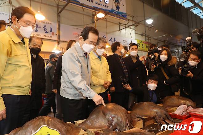 설 명절을 하루 앞둔 10일 오후 광주 서구 양동수산시장에서 정세균 국무총리가 홍어를 눌러보고 있다.2021.2.10/뉴스1 © News1 허단비 기자