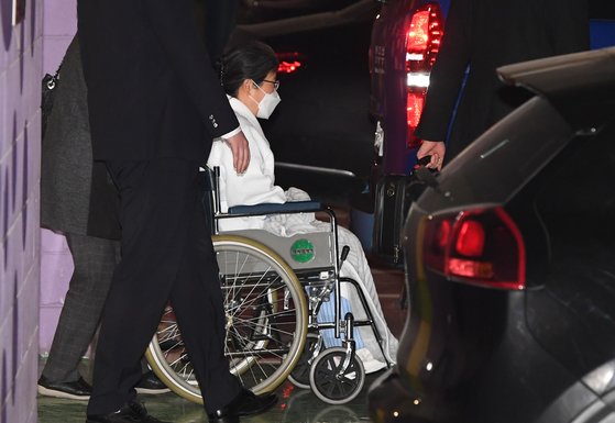 박근혜 전 대통령이 휠체어에 탄 채 경호요원 등의 보호를 받으며 차량에 탑승하고 있다. 뉴스1