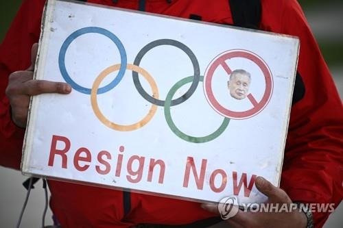 (도쿄 AFP=연합뉴스) 모리 요시로(森喜朗) 도쿄 올림픽·패럴림픽 조직위원회 회장(위원장에 해당)의 여성 멸시 발언에 대한 비판이 쇄도하는 가운데 11일 일본 도쿄도(東京都) 소재 올림픽 박물관 인근에서 한 시민이 모리의 사임을 요구하는 피켓을 들고 있다.