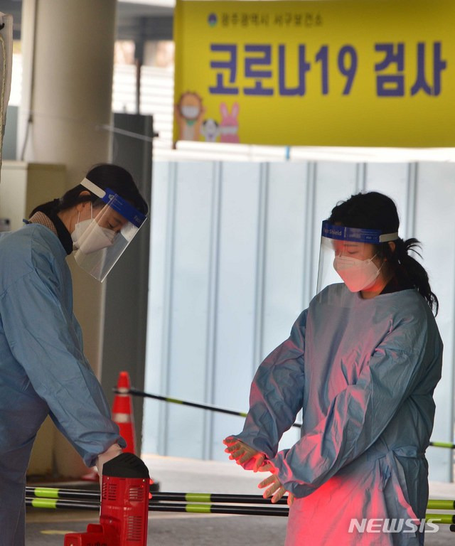 [광주=뉴시스] 변재훈 기자 = 설 명절 당일인 12일 오전 광주 서구보건소 선별진료소에서 의료진이 난로 주변에서 손을 녹이고 있다. 2021.02.12. wisdom21@newsis.com