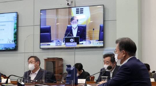 문재인 대통령이 16일 오후 청와대에서 화상회의 형식으로 열린 국토교통부 2021년 업무보고에서 변창흠 국토교통부 장관의 보고를 받고 있다. <연합뉴스>