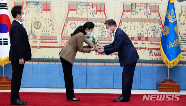 [서울=뉴시스]추상철 기자 = 문재인 대통령이 15일 오전 청와대 본관에서 황희 문화체육관광부 장관 배우자에게 꽃다발을 전달하고 있다. 2021.02.15. scchoo@newsis.com