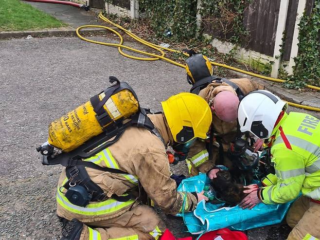 영국 현지시간으로 지난 13일, 잉글랜드 링컨에서 발생한 화재 현장에서 소방관들이 고양이 두 마리에게 산소마스크를 씌우고 응급처치를 하고 있다(링컨소방센터 페이스북)