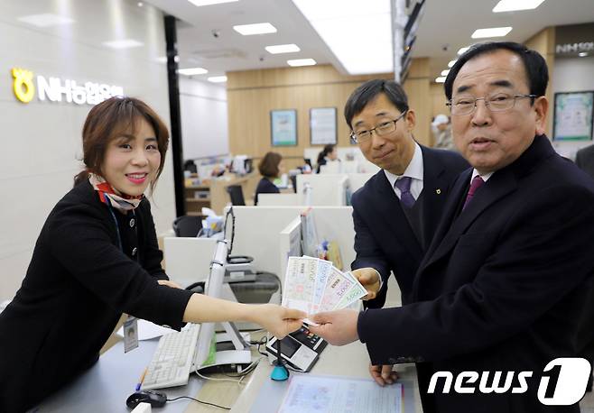 김준성 영광군수(오른쪽 첫번째)가 지역화폐인 '영광사랑상품권'을 구입하고 있다. © News1