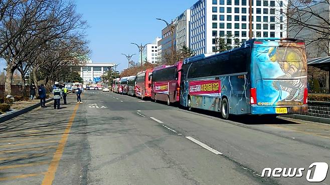 전세버스연대지부 조합원들이 18일 서울 영등포 KDB산업은행 본사 옆에서 '제2차 전세버스 노동자대회' 참석을 위해 준비 중이다. 2021.2.18/뉴스1 © News1 김도엽 기자