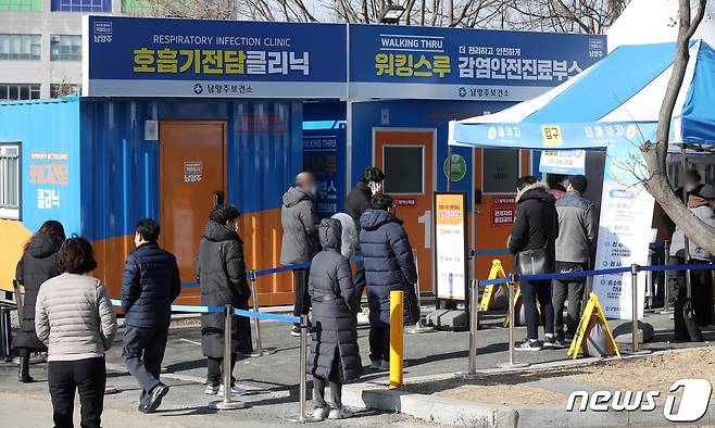 18일 오전 경기 남양주시 남양주보건소 마련된 선별진료소에서 시민들이 신종 코로나바이러스 감염증(코로나19) 진단검사를 받기 위해 줄을 서 기다리고 있다. 경기 남양주시 진관산업단지에서 신종 코로나바이러스 감염증(코로나19) 집단감염이 발생해 방역당국이 비상이다. 진관산단 코로나19 집단감염은 지난 13일 캄보디아 국적 근로자 1명이 확진된 이후 17일 114명, 추가 3명에 이어 이날 오전 전수검사 결과 3명이 늘어 총 121명의 확진자가 나왔다. 2021.2.18/뉴스1 © News1 민경석 기자