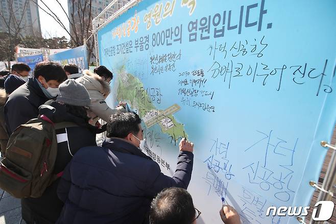 18일 오후 부산 연제구 부산시청 앞 광장에서 열린 '가덕신공항 특별법 제정 촉구 출정식'에서 가덕도신공항국민행동본부가 염원의 벽 건립을 촉구하는 내용의 서명을 하고 있다. 2021.2.18 /뉴스1 © News1 여주연 기자