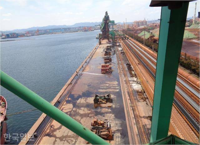 포스코 포항제철소 원료부두 전경. 선박에서 철광석을 퍼 올리는 하역기와 함께 오른쪽에는 철광석을 제철소 내 각 공장으로 운반하는 컨베이어가 설치돼 있다. 금속노조 포지트분회 제공