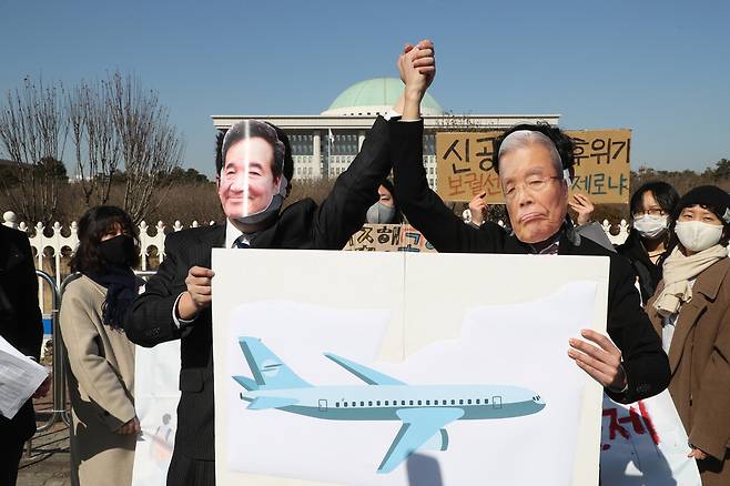 지난 9일 서울 여의도 국회 앞에서 열린 가덕도 신공항 특별법 반대 기자회견에서 청년기후긴급행동과 부산 청년 기후위기 단체 ‘기후용사대’ 회원들이 더불어민주당 이낙연 대표와 국민의힘 김종인 비대위원장 얼굴 가면을 쓰고 신공항 특별법 반대 행위극을 하고 있다. 연합뉴스