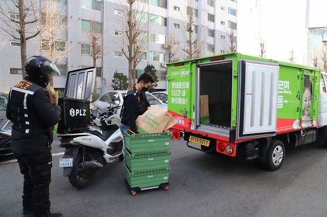 한 아파트 단지에서 오토바이 배달원이 롯데마트에서 실어 온 상품을 받아 들고 있다. 롯데온은 차량 배송기사가 직접 운전부터 집 앞 배송까지 모두 책임지는 기존 방식과 차별화된 릴레이 배송을 시범 서비스 중이다. /사진=롯데온 제공