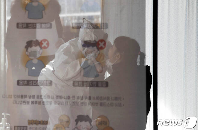 17일 오후 광주 북구선별진료소에서 방호복을 입은 의료진이 코로나19 검체 채취를 진행하고 있다.(광주북구 제공)2020.12.17/뉴스1 © News1 허단비 기자