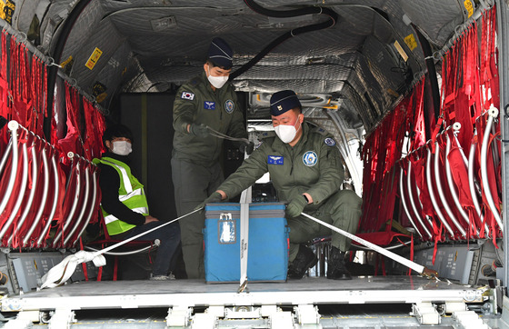 Military officials secure a container on the Air Force’s Boeing CH-47 Chinook helicopter at Icheon, Gyeonggi, Friday, taking part in a governmental mock drill running through the distribution of Covid-19 vaccines to remote areas without access to airports. [JOINT PRESS CORPS]