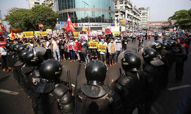 미얀마 최대 도시 양곤에서 19일(현지시간) 군부 쿠데타 규탄 시위대가 도열한 진압 경찰과 대치하고 있다. 양곤 AP=연합뉴스