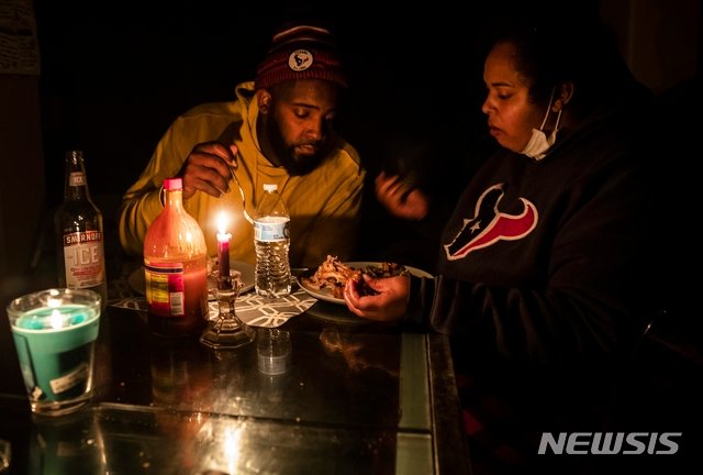 16일(현지시간) 미국 텍사스 글렌우드 지역의 한 가족이 촛불을 켠 채 식사를 하고 있다. 미국 남부를 강타한 한파가 텍사스주(州)에서는 전력 수요가 급증하며 블랙아웃 사태가 불거졌다. 사진=AP/뉴시스