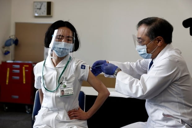 일본이 신종 코로나바이러스 감염증(코로나19) 백신 접종을 개시한 17일 도쿄에서 한 의료종사자(왼쪽)가 백신을 접종받고 있다/사진=EPA