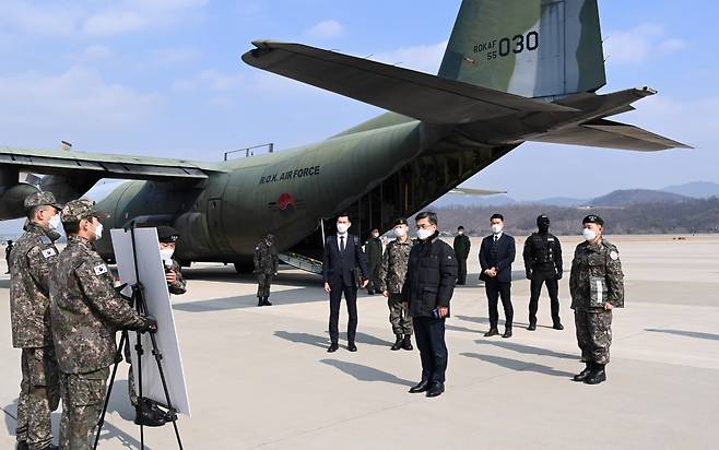 Defense Minister Suh Wook (front) is briefed on the military drill conducted to ship the first batch of coronavirus vaccines with an Air Force transporter plane at Seoul Air Base, Feb. 19, 2021. (Yonhap)