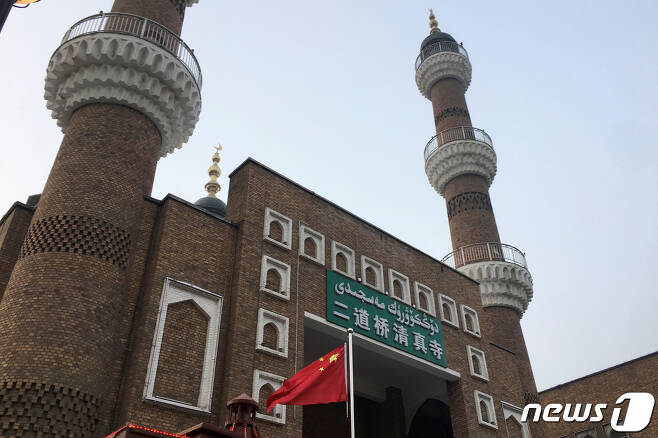 중국 신장 자치구 무슬림계 소수민족 위구르족의 모스크 사원 앞에 중국기가 펄럭이는 모습. © 로이터=뉴스1 자료 사진