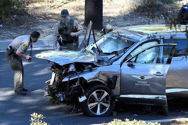 23일(현지 시각) 캘리포니아주 로스엔젤레스 카운티 보안관들이 우즈의 사고 차량을 살펴보고 있다. /로이터 연합뉴스