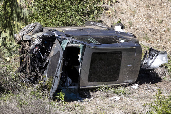 미국의 ‘골프 황제’ 타이거 우즈의  스포츠유틸리티차(SUV) 차량이 23일(현지시간) 캘리포니아주 로스앤젤레스 랜초 팔로스버디스 구역에서 전복되는 사고가 발생한 후 차량이 크게 훼손된 채 도로 옆 산비탈에 쓰러져 있다.EPA 연합뉴스