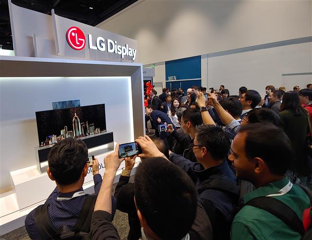 지난 5월 미국 캘리포니아주 새너제이에서 열린 ‘국제정보디스플레이학회(SID) 2019’에서 관람객들이 LG디스플레이 부스에 전시된 65인치 롤러블 OLED TV를 관심 있게 지켜보고 있다.LG디스플레이 제공