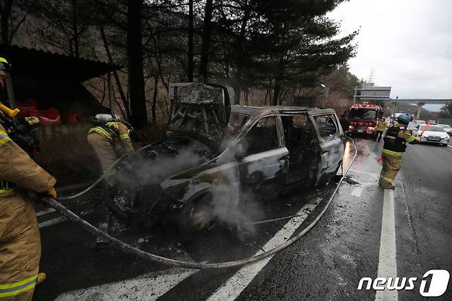 26일 오전 8시20분쯤 경남 김해시 대청동 불모산터널 창원방향 진입 500m 전 도로에서 카니발이 불이 나 소방대원이 진화작업을 벌이고 있다.(경남소방본부 제공)2021.2.26. © 뉴스1