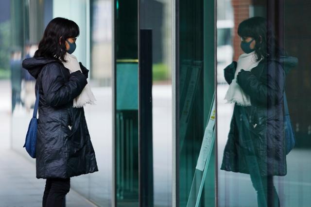 26일 일본 도쿄에서 코로나19 확산 방지를 위해 마스크를 쓴 한 여성이 창문에 비친 자신의 모습을 바라보며 목도리를 매만지고 있다. 도쿄도는 26일 270명 이상의 코로나19 신규 확진자가 발생했다고 밝혔다. 도쿄=AP 뉴시스