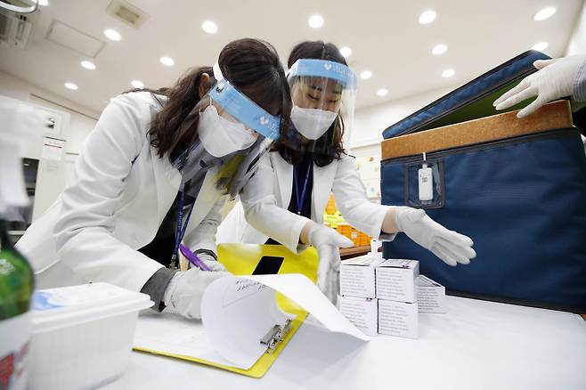 Public health center employees in Gwangju check the delivered batches of COVID-19 vaccines from AstraZeneca on Thursday. (Gwangju City Buk-gu)