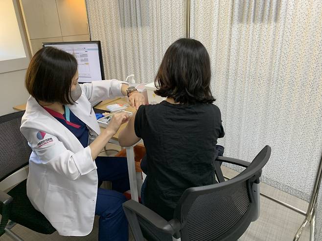 A health care worker bandages an injection site. (Kim Arin/The Korea Herald)
